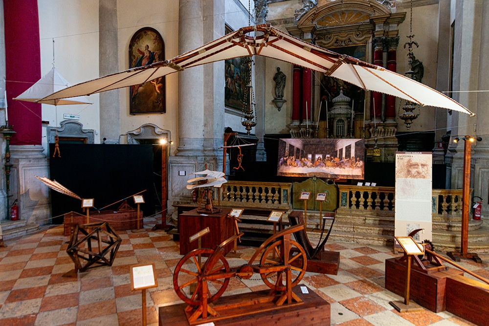 Intérieur d'une église catholique dans laquelle sont exposées des modèles de machines en bois inspirées des dessins de Leonardo da Vinci